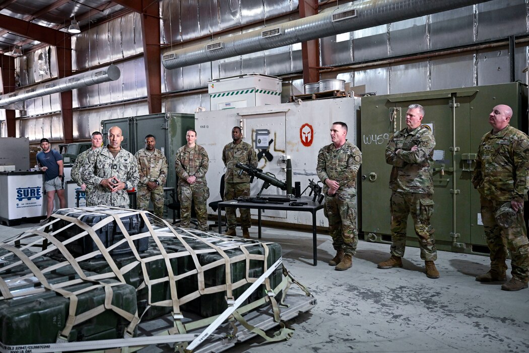 A group of military members talk together inside.
