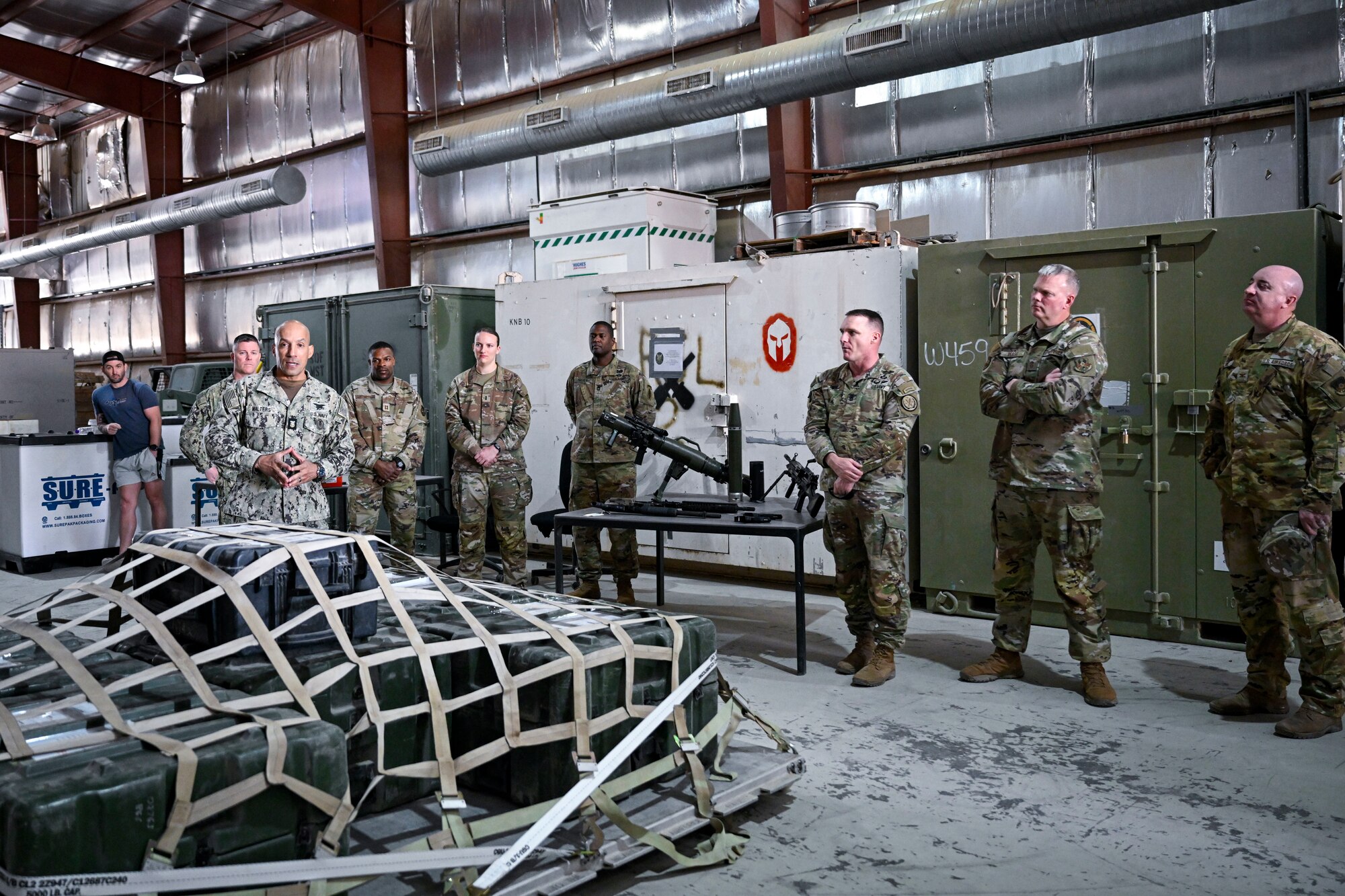 A group of military members talk together inside.