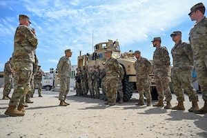 A group of military members talking together outside.