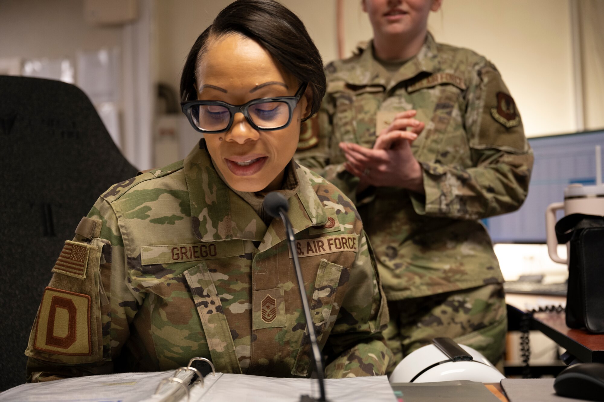 U.S. Air Force Chief Master Sgt. Tiffany Griego, 100th Air Refueling Wing command chief, speaks into the giant voice broadcasting system’s mic at RAF Mildenhall, England, Mar. 11, 2025. The command post relays vital information to service members in emergency situations. (U.S. Air Force photo by Senior Airman Nash Truitt)