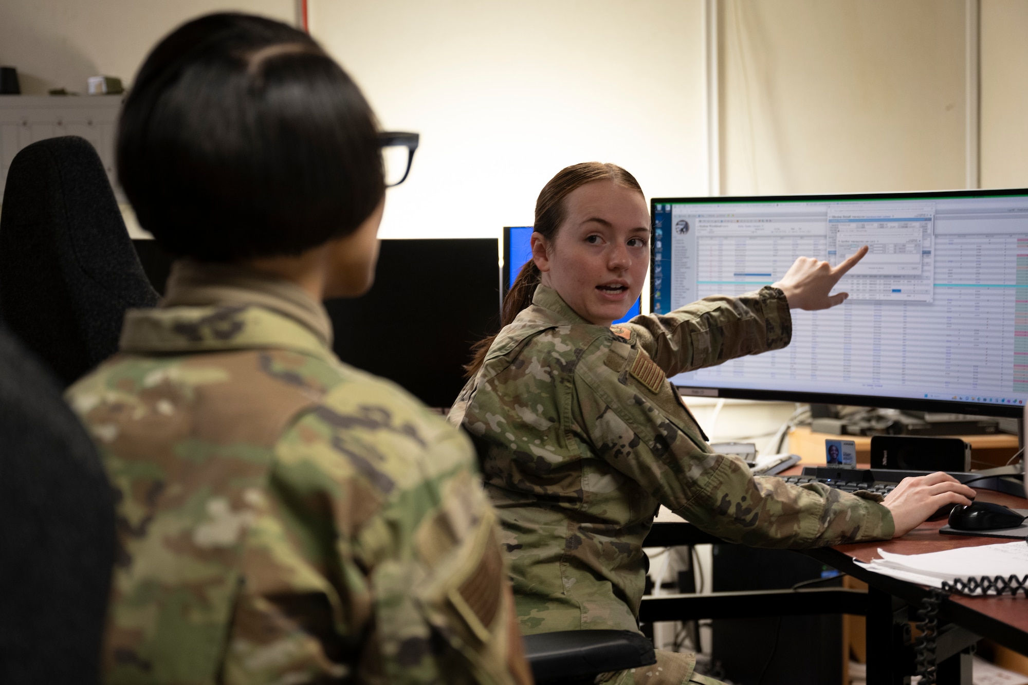 U.S. Air Force Chief Master Sgt. Tiffany Griego, left, 100th Air Refueling Wing command chief, and Airman 1st Class Anna Smith, 100th ARW Command Post emergency actions controller, process information in an accounting system at RAF Mildenhall, England, Mar. 11, 2025. The command post relays vital information to service members in emergency situations. (U.S. Air Force photo by Senior Airman Nash Truitt)