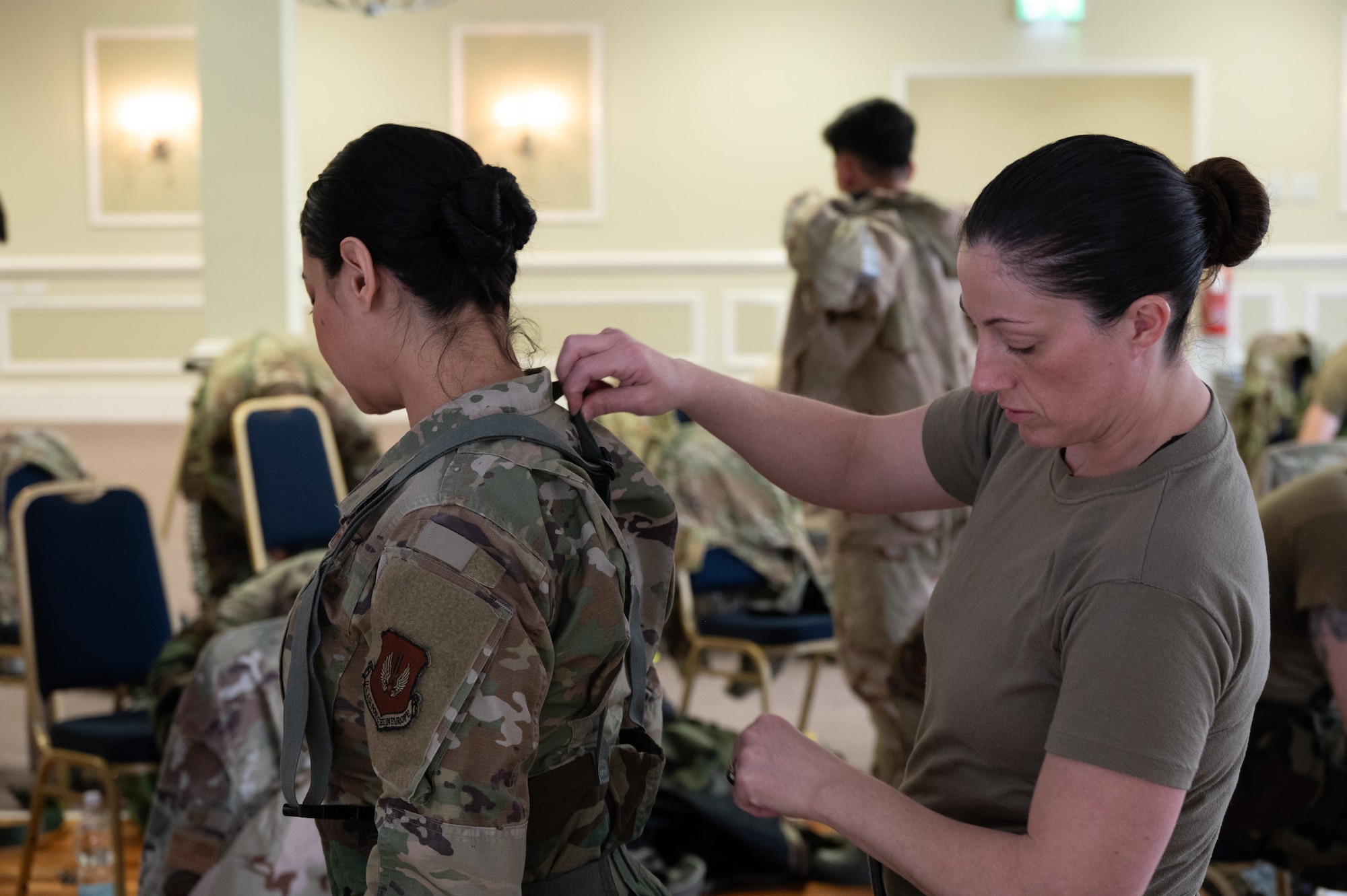 Pathfinders help each other suit up in Mission-Oriented Protective Posture