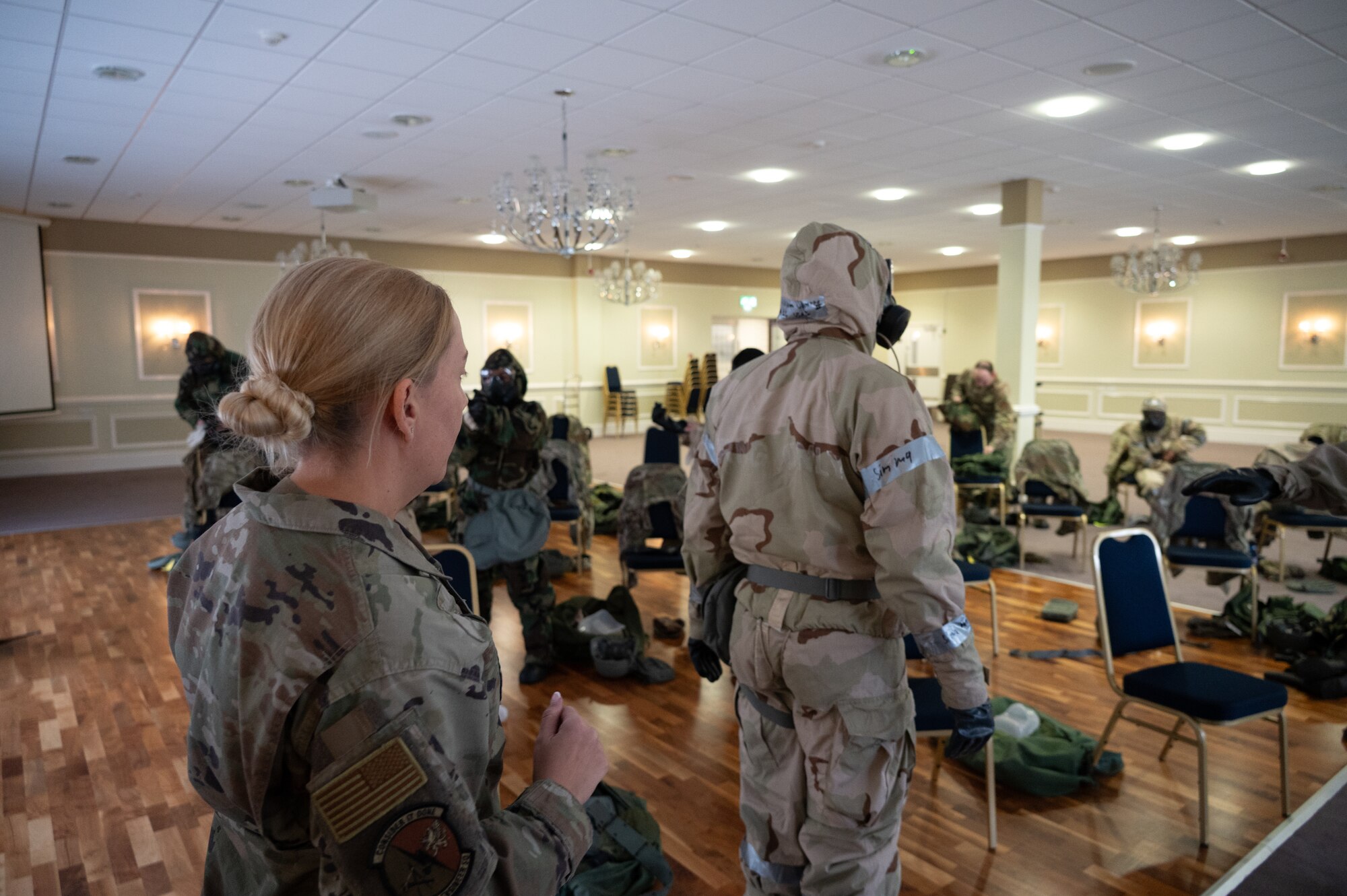 U.S. Air Force Master Sgt. Shannon Lee, 501st Combat Support Wing emergency manager, looks over Mission-Oriented Protective Posture (MOPP) gear