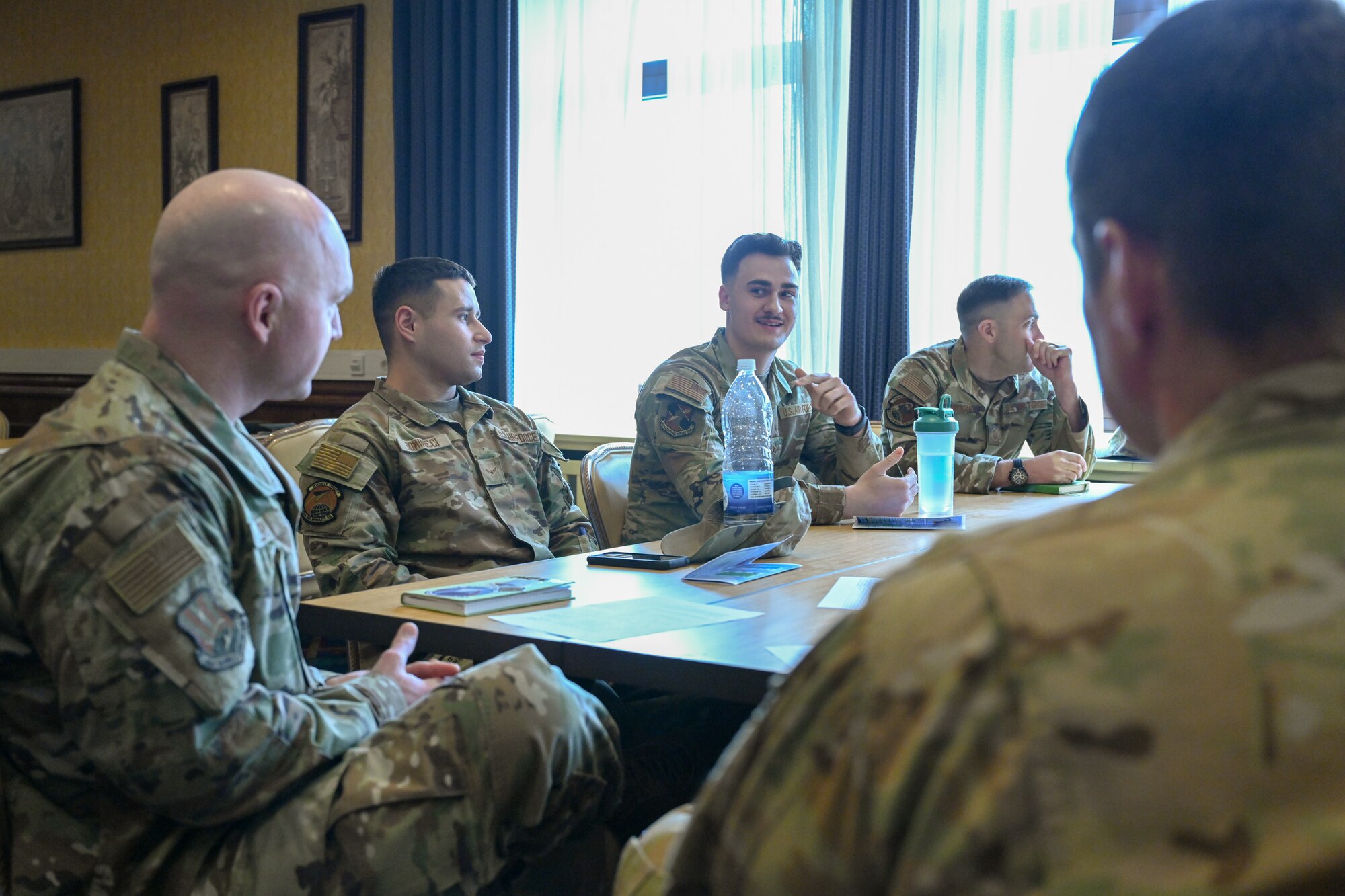 Airmen assigned to the 521st Air Mobility Operations Wing talk with Chief Master Sgt. Scott Piper, left, 521 AMOW command chief, and Col. Jordan Norman, right, 521 AMOW commander, during a speed mentoring session at the Armstrong Club on Vogelweh Military Complex, Germany, Feb. 19, 2025.