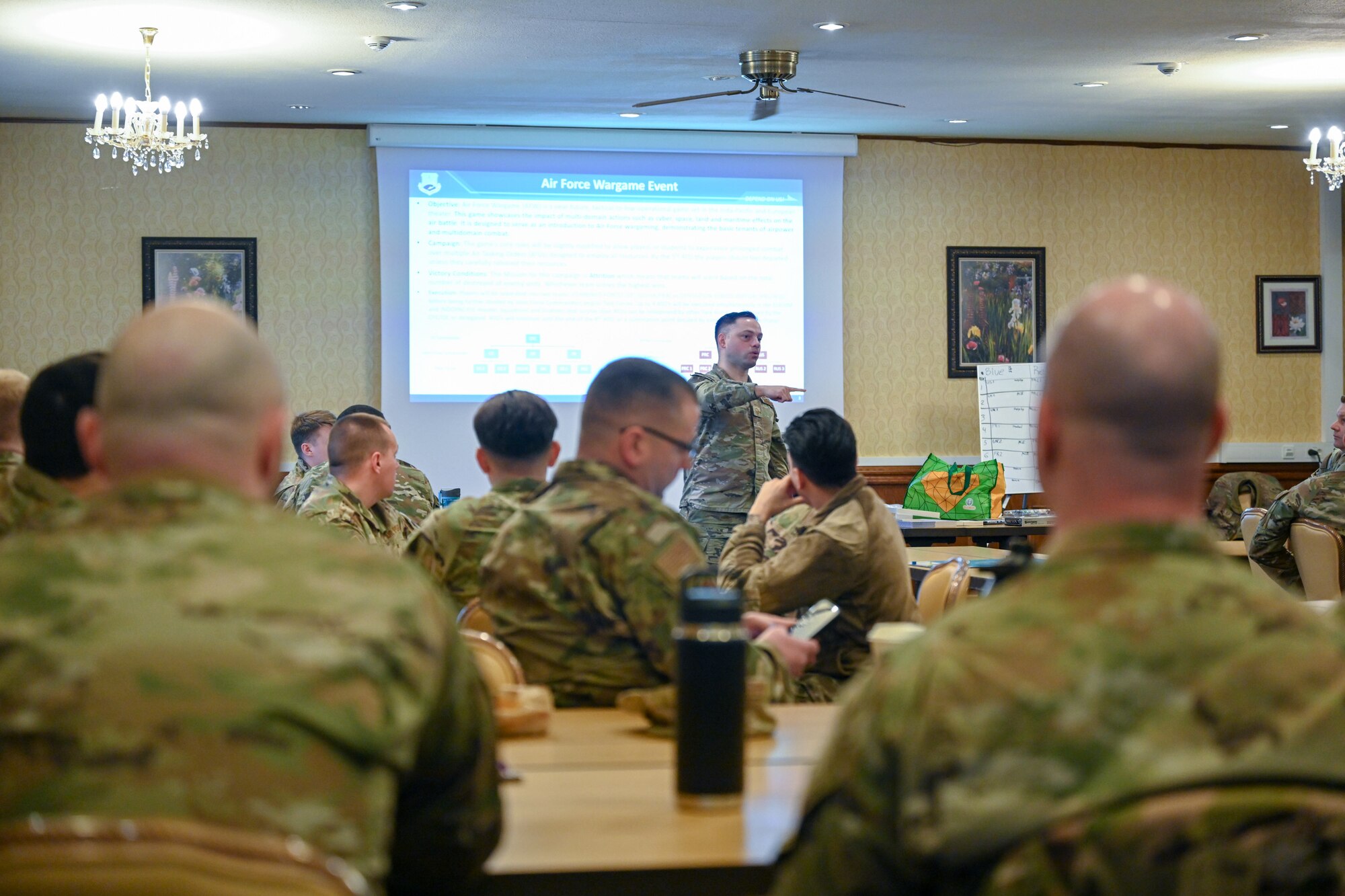 Master Sgt. Nathan Buckwalter, 521st Air Mobility Operations Wing european enroute maintenance superintendent, explains the instructions of an Air Force Wargame Europe and Indo-Pacific Expansion board game to Airmen assigned to the 521 AMOW during a professional development seminar at the Armstrong Club on Vogelweh Military Complex, Germany, Feb. 20, 2025.