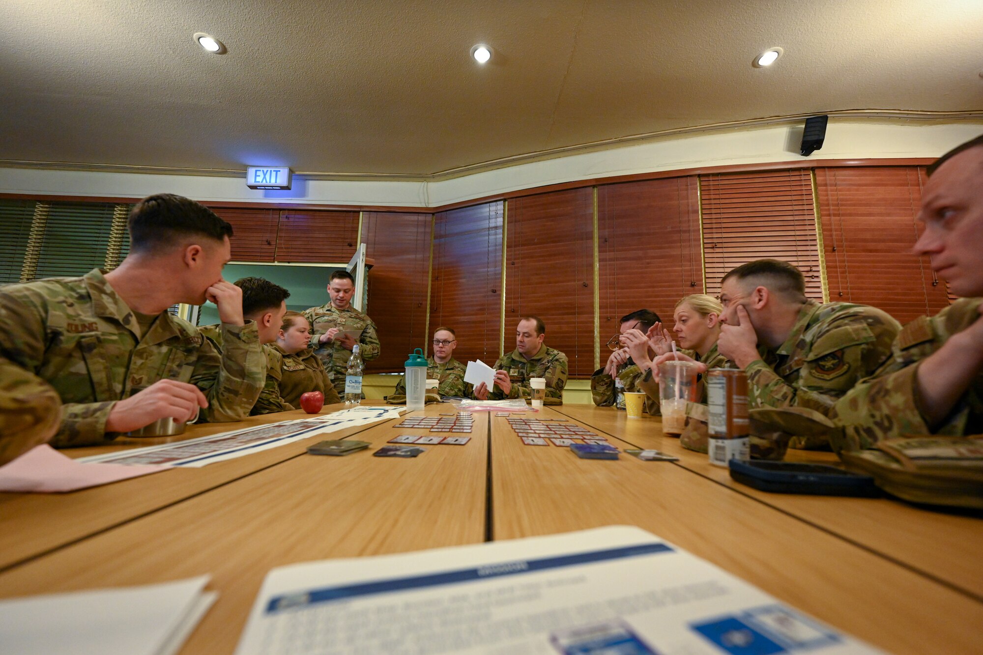 Airmen assigned to the 521st Air Mobility Operations Wing discuss strategies for the Air Force Wargame Europe and Indo-Pacific Expansion board games during a professional development seminar at the Armstrong Club on Vogelweh Military Complex, Germany, Feb. 20, 2025.