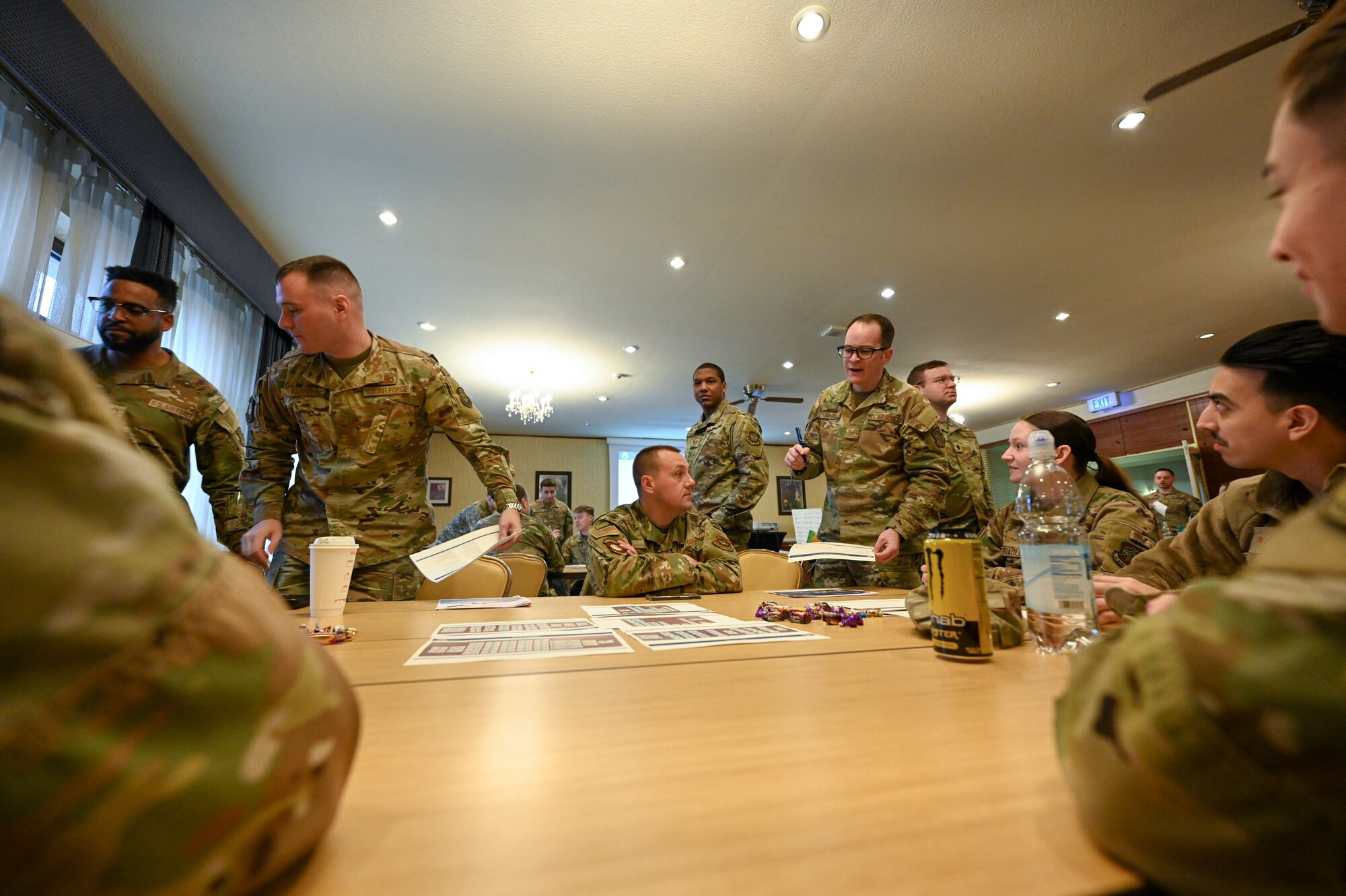 Airmen assigned to the 521st Air Mobility Operations Wing discuss strategies for an Air Force Wargame Europe and Indo-Pacific Expansion board games during a professional development seminar at the Armstrong Club on Vogelweh Military Complex, Germany, Feb. 20, 2025.