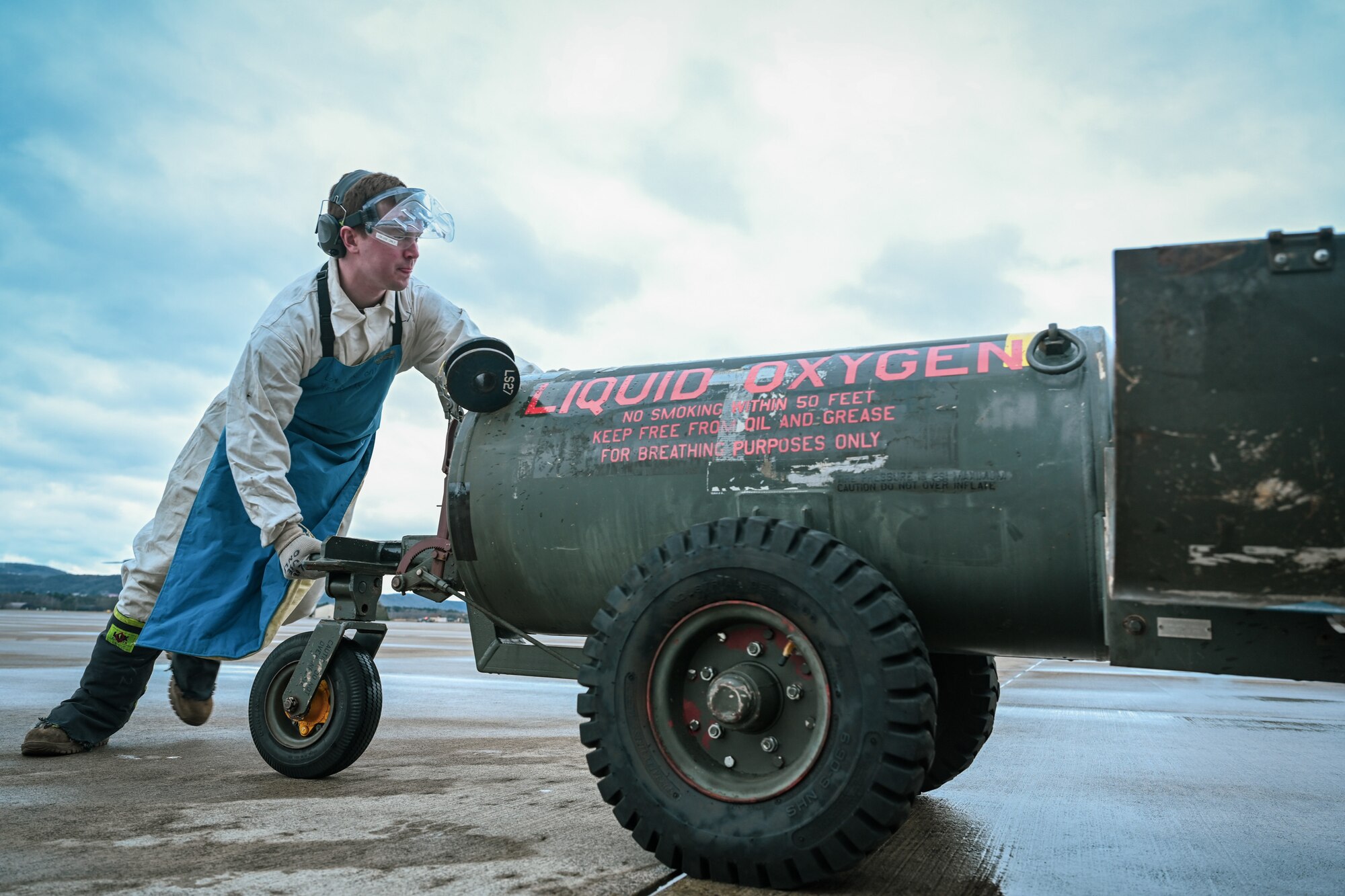 Staff Sgt. Terry McGivern, a 726th Air Mobility Squadron heavy integrated avionics craftsman, pushes a liquid oxygen servicing cart, in preparation for servicing a C-17A Globemaster III liquid oxygen converter on Ramstein Air Base, Germany, Feb. 26, 2025.