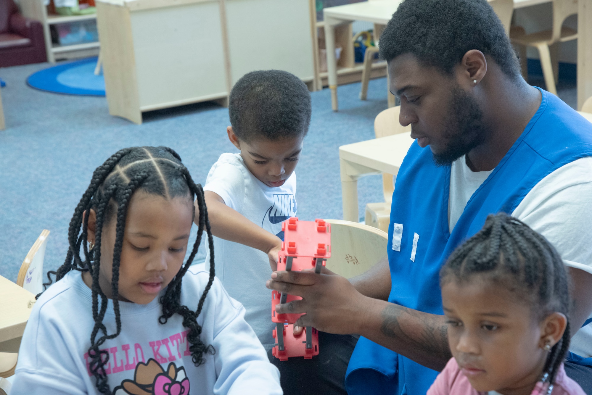 Jaiquez K. Smith, a child and youth program assistant, helps a child with a toy at the Judith P. Hoyer Child Development Center at Joint Base Andrews, Md., Feb. 25, 2025. Smith attended the CDC as a child and still echoes advice from his teachers then when working with children in his classroom. (U.S. Air Force photo by Patrick Griffith)