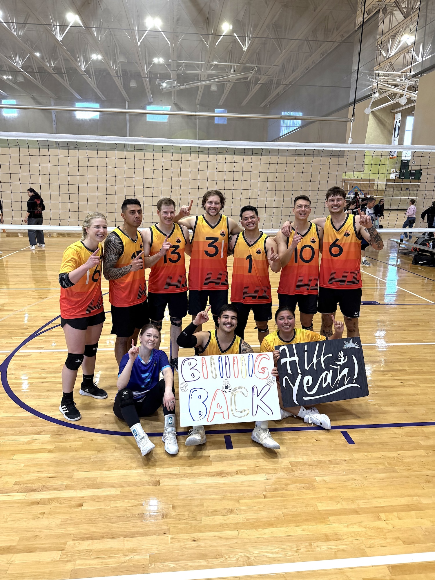 volleyball players form up by the net for a group shot