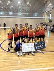 volleyball players form up by the net for a group shot