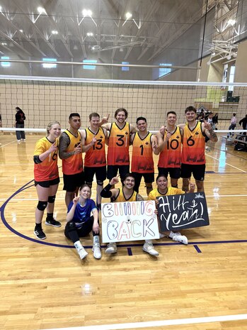 volleyball players form up by the net for a group shot