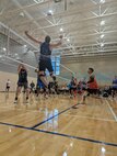 A volleyball player jumps to hit the ball