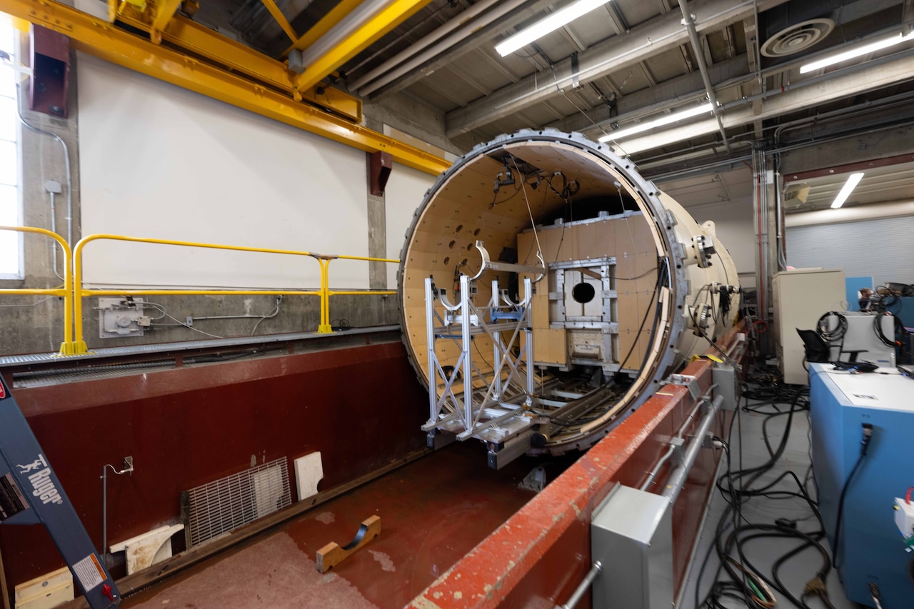 Half of a massive pressure chamber sits open and empty.