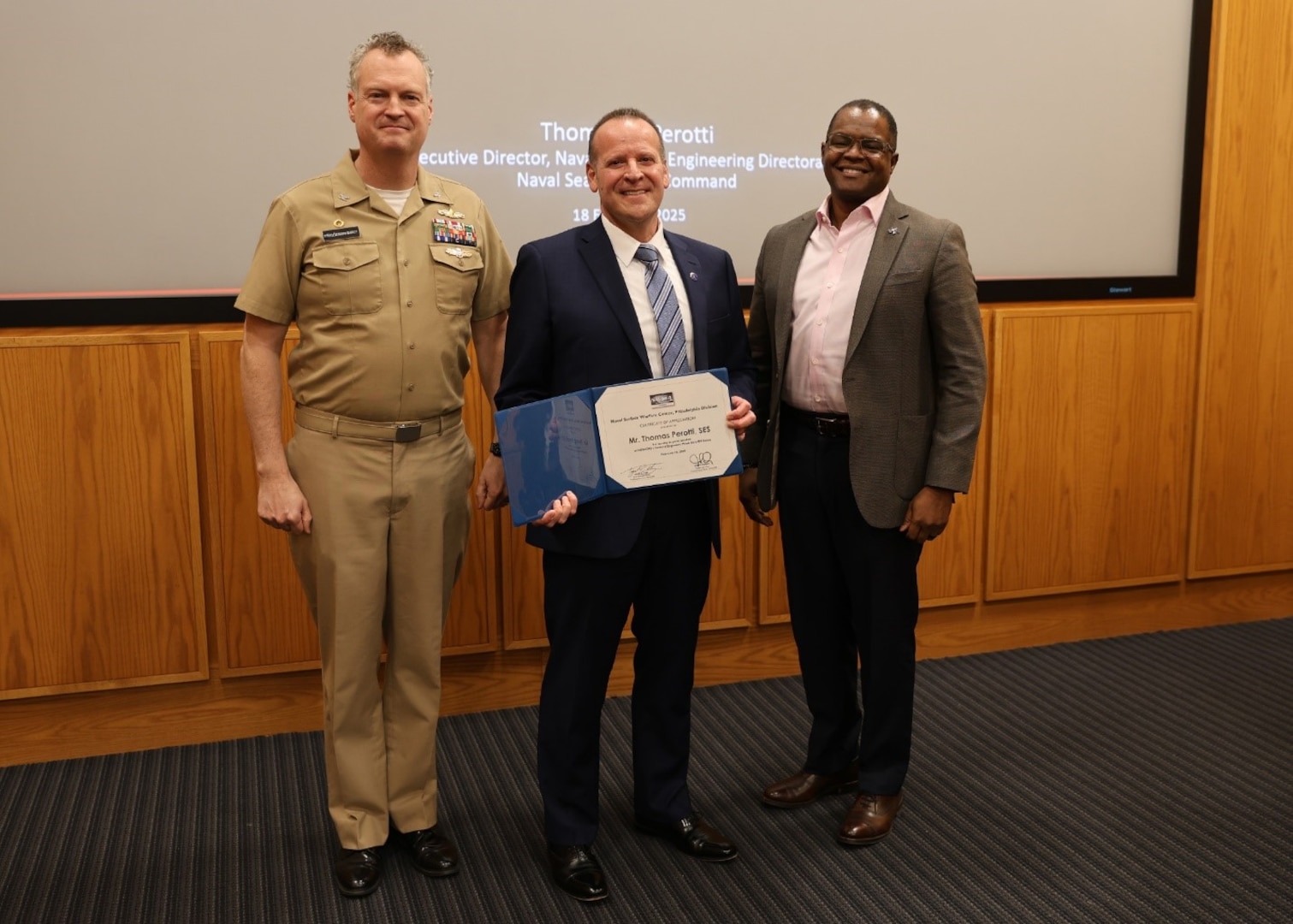 Naval Surface Warfare Center, Philadelphia Division (NSWCPD) Commanding Officer Capt. Joseph Darcy (left) and Technical Director Nigel C. Thijs, SES (right) present the a Certificate of Appreciation to Thomas Perotti, Naval Sea Systems Command (NAVSEA) Executive Director for its Naval Systems and Logistics Directorate (SEA 05) (center), for serving as the command’s National Engineers Week Kick-Off Event keynote speaker on Feb. 18, 2025. (U.S. Navy photo by Phil Scaringi, ctr)