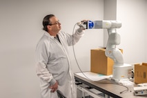 A person works near a piece of equipment in a work area.