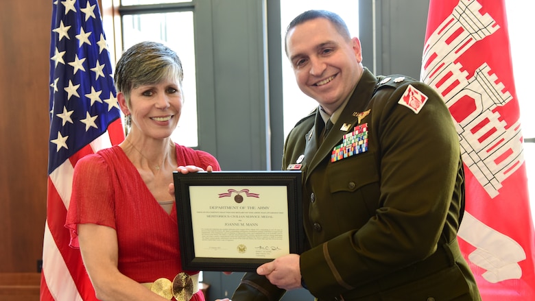 Lt. Col. Robert Green, U.S. Army Corps of Engineers Nashville District commander, presents the Department of the Army Meritorious Civilian Service Medal to Joanne Mann, Nashville District executive officer and congressional liaison, during a retirement ceremony March 12, 2025, at the Nashville Public Library in Nashville, Tennessee. Mann culminates 38 years of federal service. (USACE Photo by Lee Roberts)