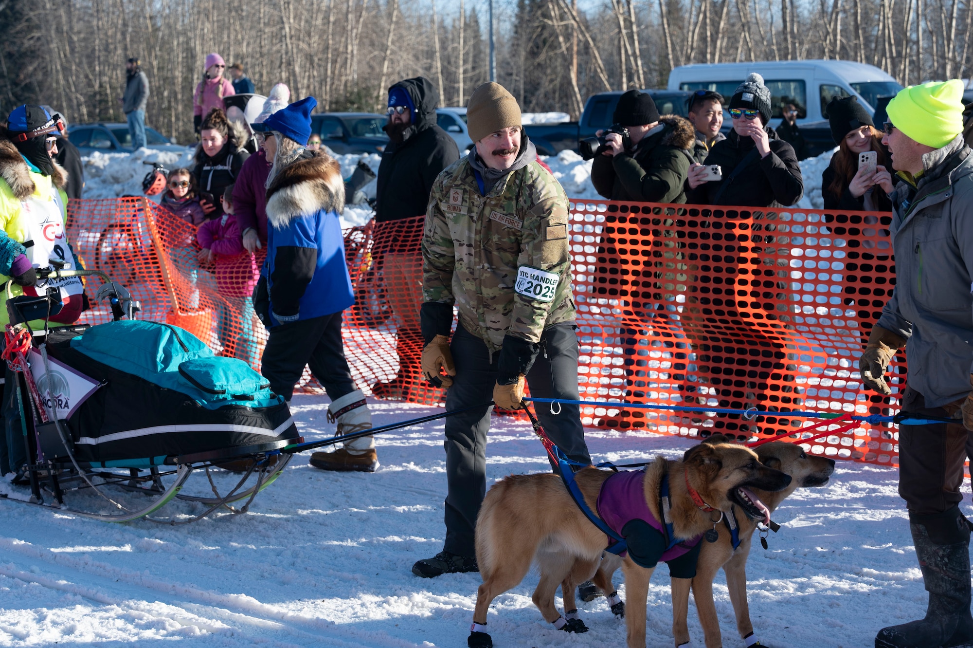 Alaska Air National Guard Senior Master Sgt. Keith Rowan, an air refueling boom operator at the 168th Wing, volunteers as a dog handler, assisting the mushers in moving their teams to the start line of the 2025 Iditarod.