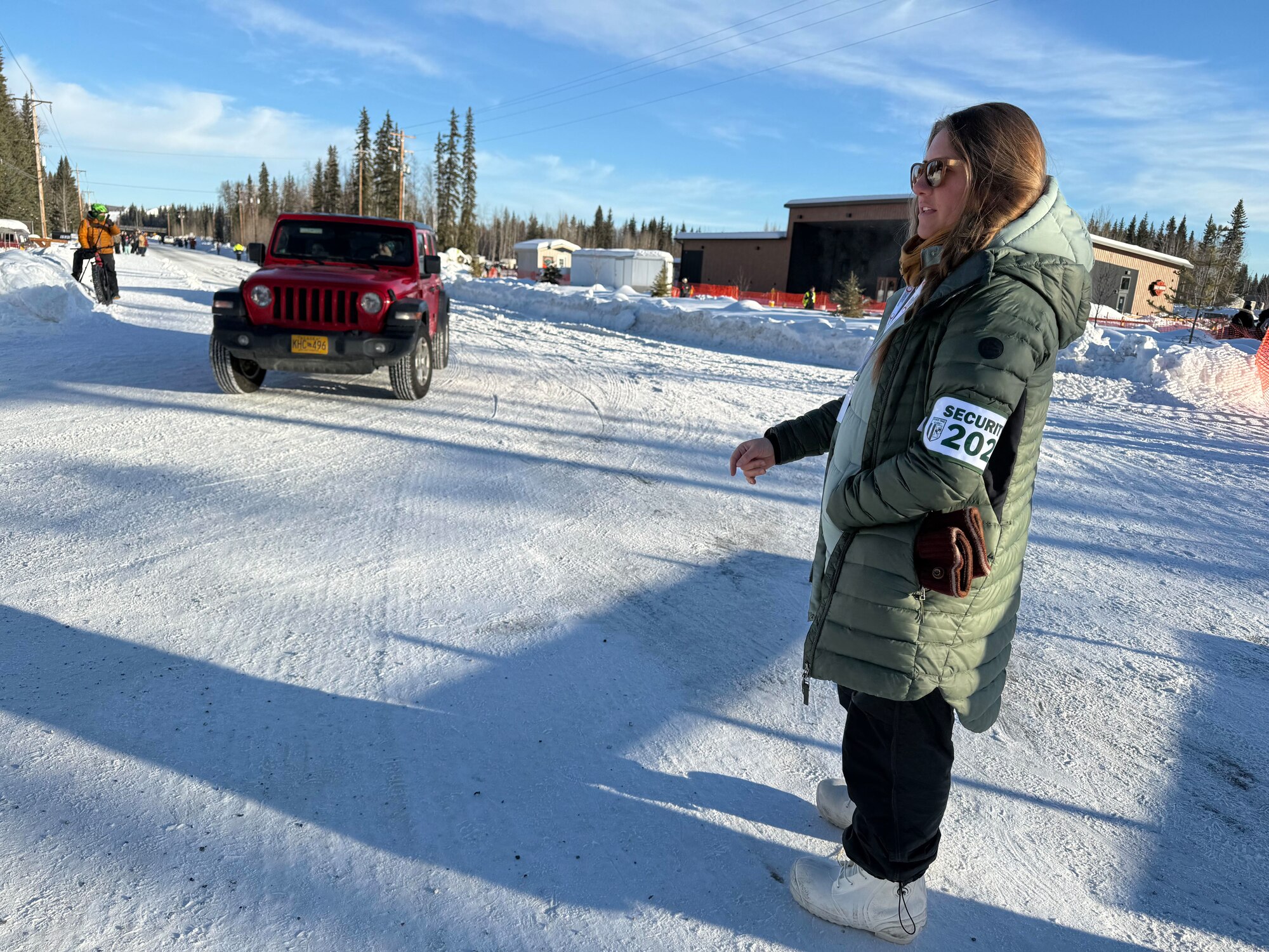 Alaska Air National Guard Senior Airman Katlyn Schlumbohm, a KC-135 crew chief with the 168th Wing directs traffic at the start line of the 2025 Iditarod Race
