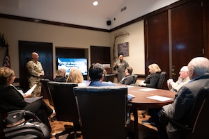 Col. Brady-Lee speaks with members while they sit at a conference table.