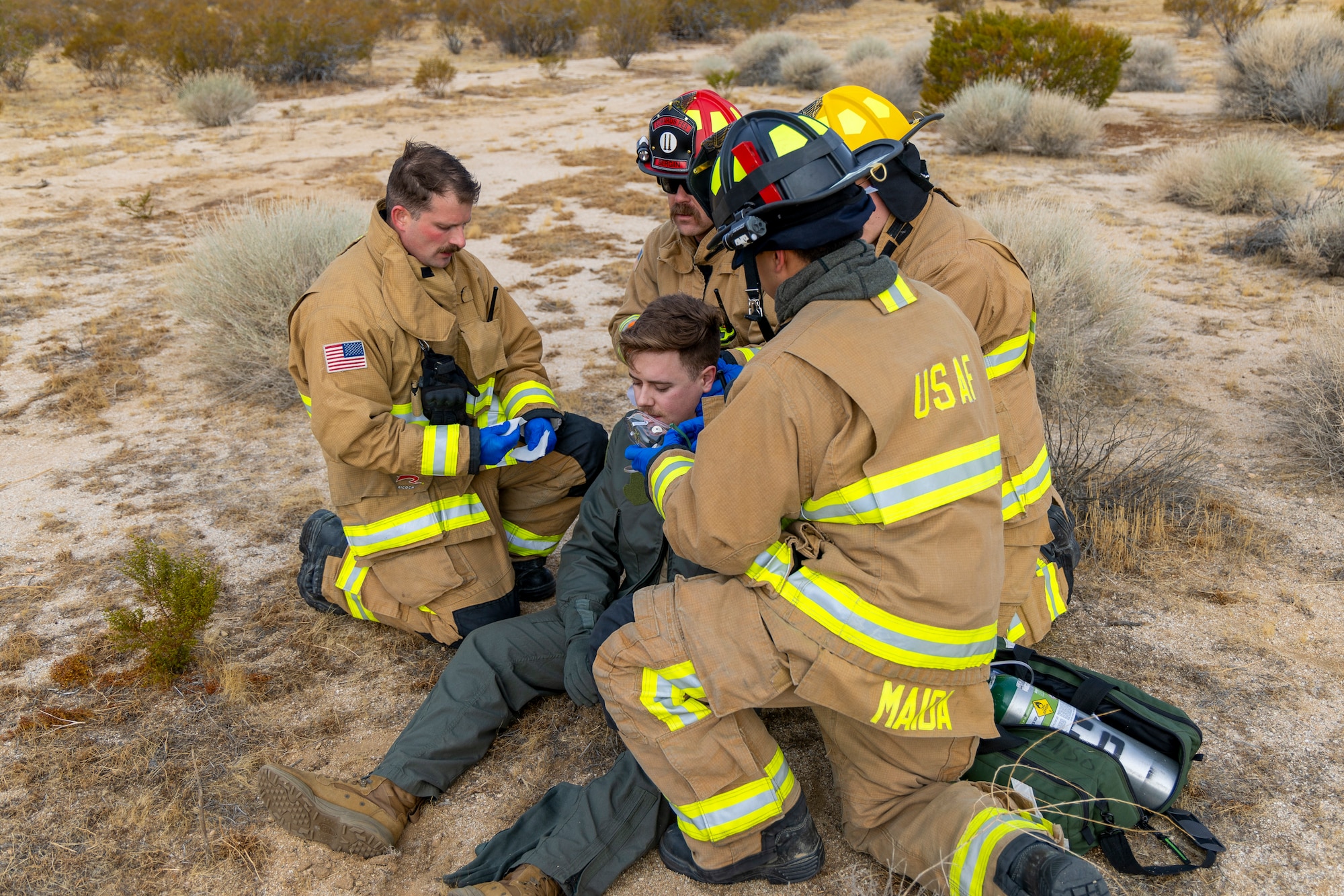 Medical first responders treat a role player during a Major Accident Response Exercise on Edwards Air Force Base, California, Feb. 12. In the exercise scenario, the role player acted as an F-22 Raptor pilot who had ejected from his aircraft following a mid-air collision with a C-12 Huron. Exercises train and prepare medical and support personnel in the event of incidents on Edwards. (Air Force photo by Kyle Brasier)