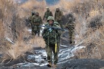 A Japan Ground Self-Defense Force paratrooper assigned to the 1st Airborne Brigade carries his equipment after landing at JGSDF East Fuji Maneuver Area, Japan, March 4, 2025, during Airborne 25.
