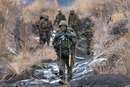 A Japan Ground Self-Defense Force paratrooper assigned to the 1st Airborne Brigade carries his equipment after landing at JGSDF East Fuji Maneuver Area, Japan, March 4, 2025, during Airborne 25.