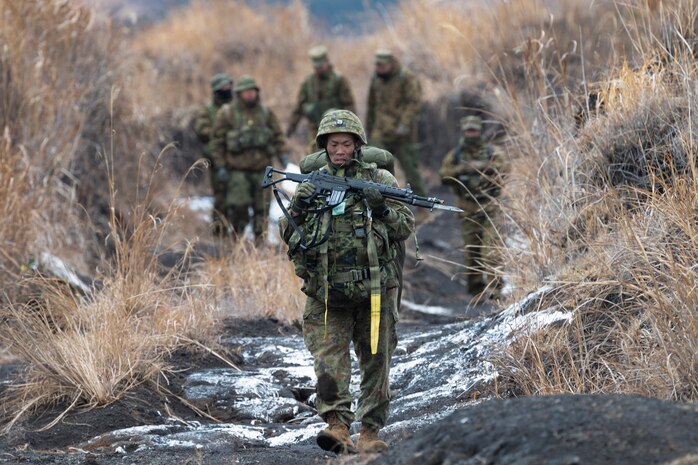 A Japan Ground Self-Defense Force paratrooper assigned to the 1st Airborne Brigade carries his equipment after landing at JGSDF East Fuji Maneuver Area, Japan, March 4, 2025, during Airborne 25.