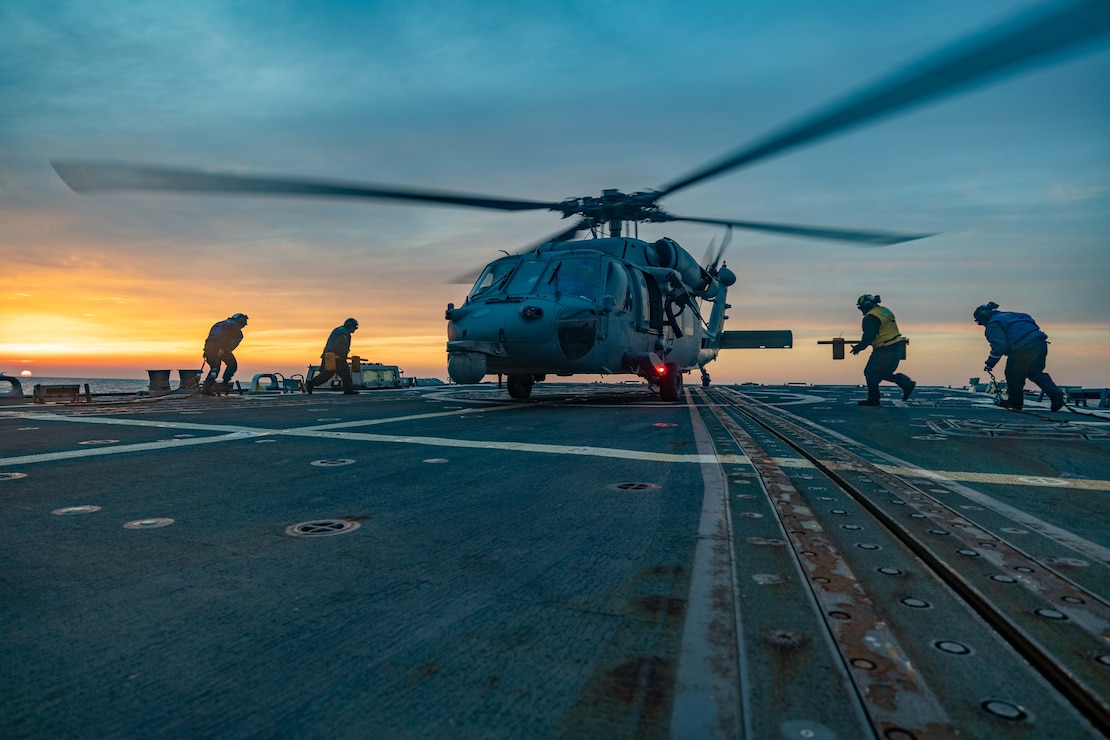 Sailors assigned to the Arleigh Burke-class guided-missile destroyer USS Ralph Johnson (DDG 114) run to chock and chain MH-60S assigned to Helicopter Sea Combat Squadron (HSC) 4 the “Black Knights” on the flight deck while underway in the Sea of Japan, March 10.