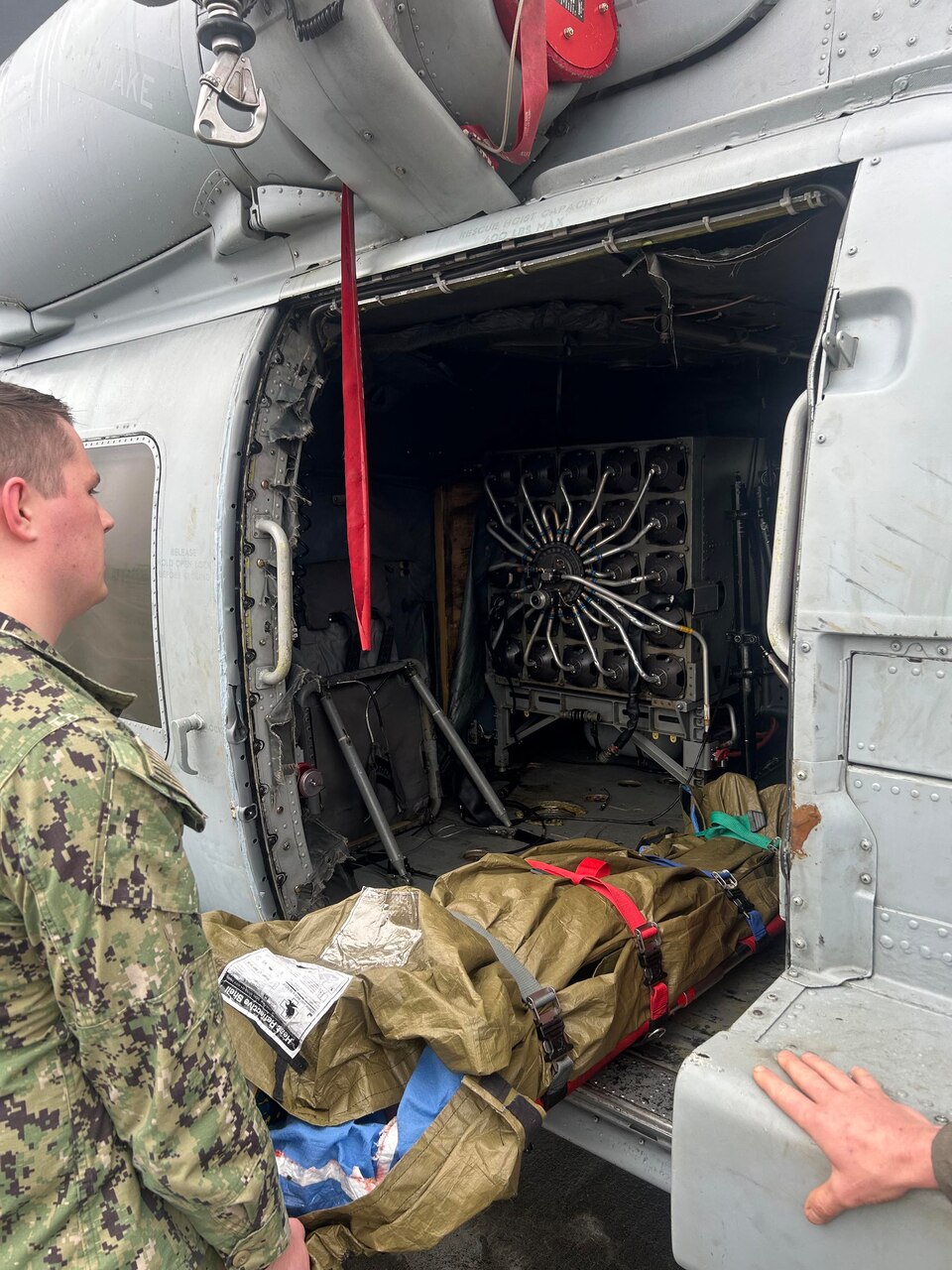 A Helicopter Maritime Strike Squadron (HSM) 50 sailor practices loading a patient in an MH-60R helicopter during casualty evacuation training, sponsored by Navy Medicine Readiness and Training Command (NMRTC) Jacksonville and Expeditionary Medical Facility-Mike Staff Education and Training (SEAT) servicemembers.