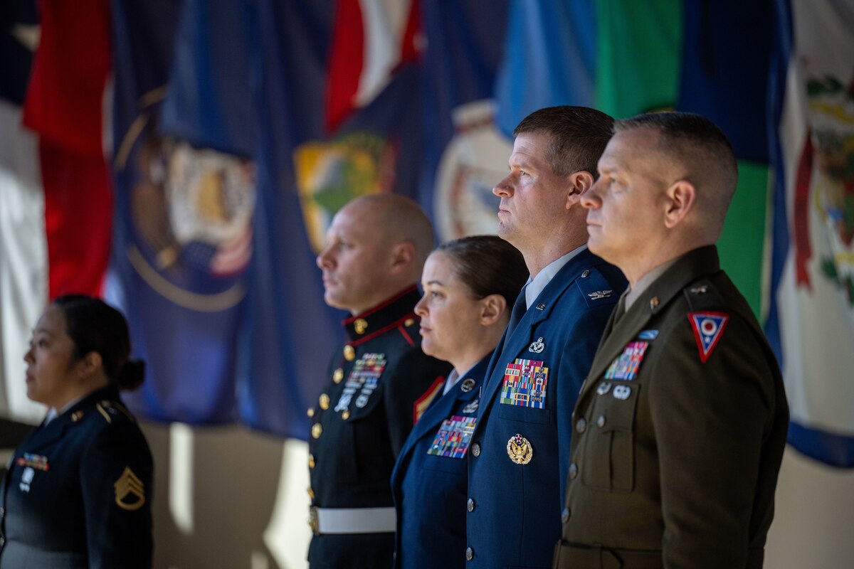 Col. Dustin Richards, 88th Air Base Wing and installation commander, stands at attention alongside representatives from other Department of Defense branches during the National Anthem at the Ohio Military Signing Day at the National Veterans Memorial Museum in Columbus, Ohio, March 11, 2025.