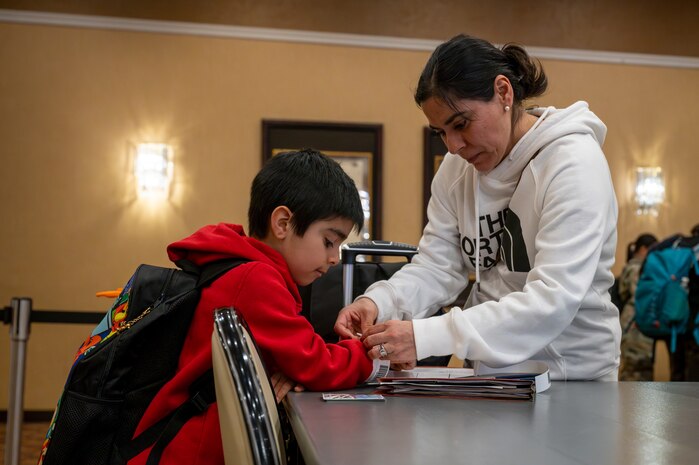 A family participating in the Emergency Evacuation Program (EEP) exercise puts on identification wristbands at Misawa Air Base, Japan, Mar. 11, 2025.