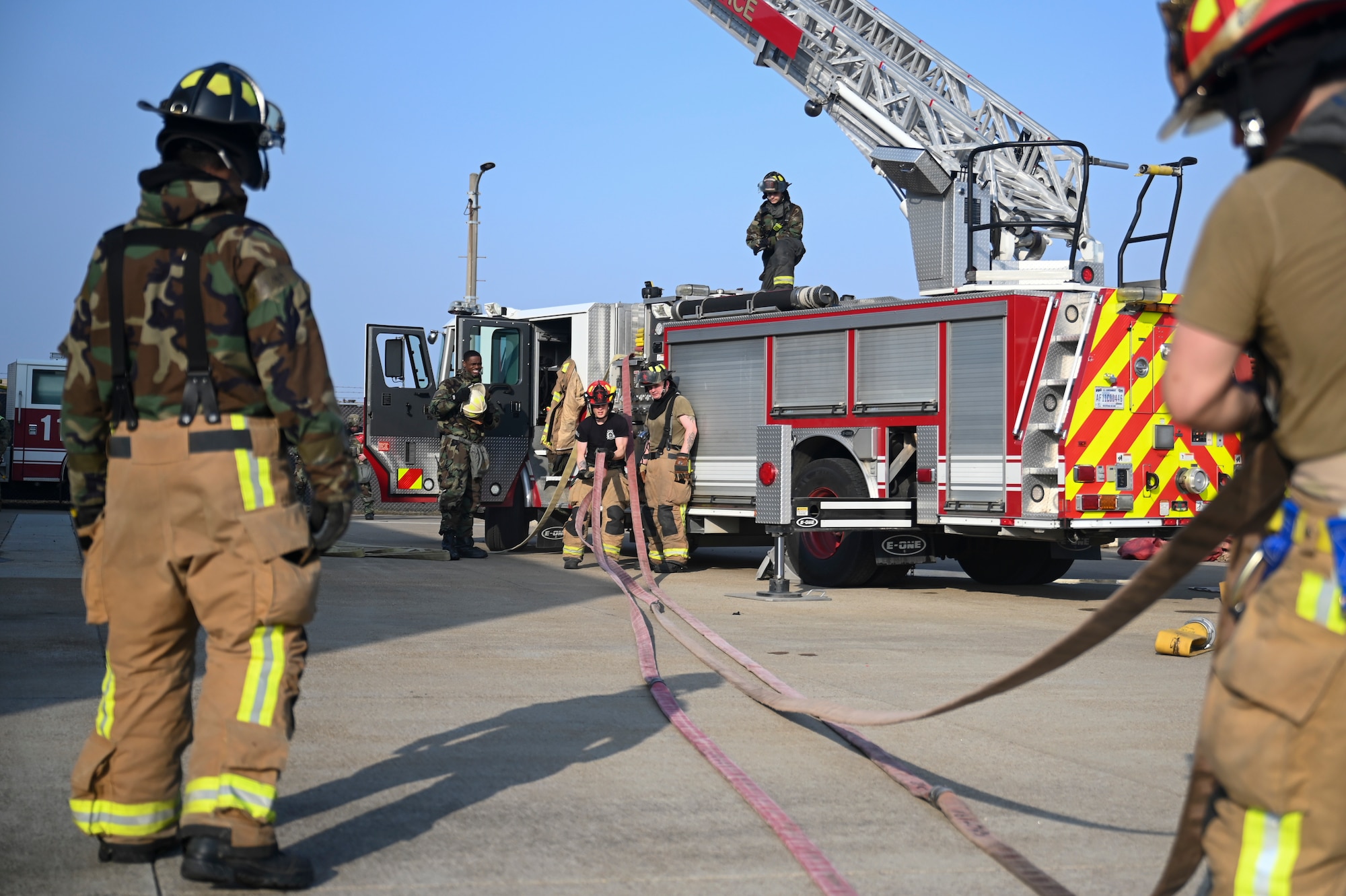 Airmen assigned to the 8th Civil Engineer Squadron fire department load a hose onto a fire truck during Freedom Shield 25.