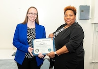 Norfolk Naval Shipyard Contracting Department Contract Specialist Ruby Decker (right) receives her certificate of completion, for the inaugural class of Contracts Management & Practical Acquisition Skills (CMPAS) Workshop, from the Contracting Department Business Operation Division Head Donyette Rodgers. Decker was one of nine to attend the 13-week program, which consisted of over 100 hours of academic instruction and 50 hours of hands-on training through mock procurements.