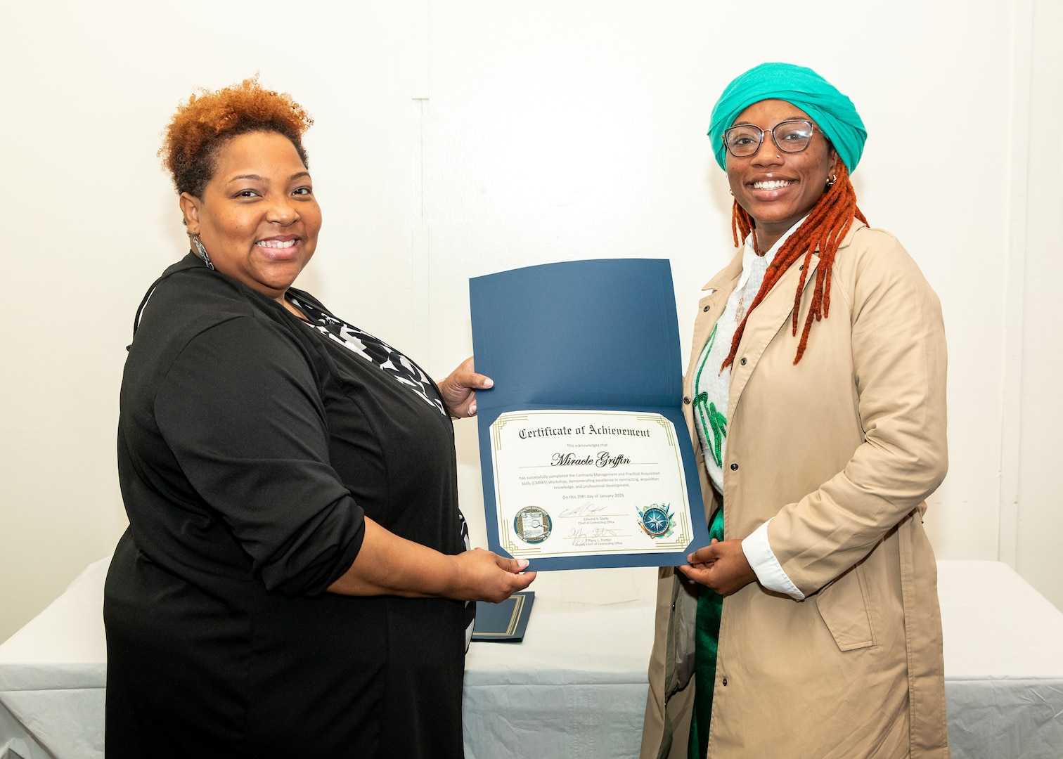 Norfolk Naval Shipyard Contracting Department Business Operation Division Head Donyette Rodgers (left) presents the Contracts Management & Practical Acquisition Skills (CMPAS) Workshop completion certificate to Contract Specialist Miracle Griffin. Griffin was one of nine to attend the inaugural 13-week program, which consisted of over 100 hours of academic instruction and 50 hours of hands-on training through mock procurements.