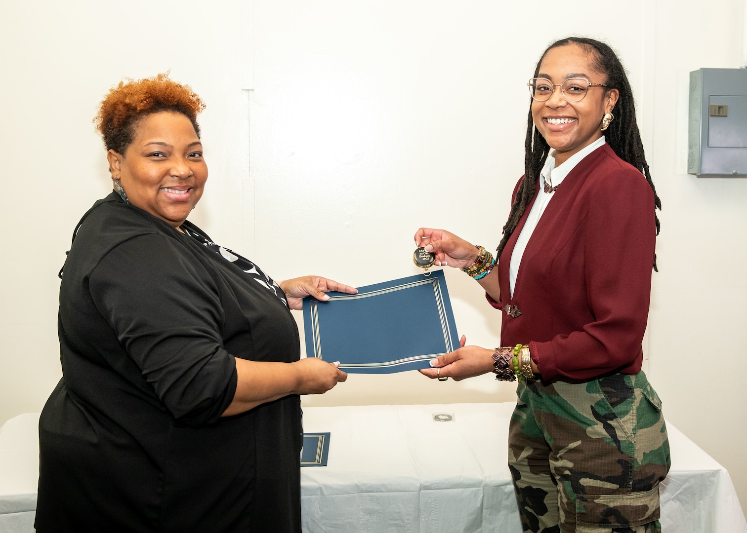 Norfolk Naval Shipyard Contracting Department Business Operation Division Head Donyette Rodgers (left) presents the Contracts Management & Practical Acquisition Skills (CMPAS) Workshop completion certificate to Contract Specialist Chaunsa Saunders. Saunders was one of nine to attend the inaugural 13-week program, which consisted of over 100 hours of academic instruction and 50 hours of hands-on training through mock procurements.
