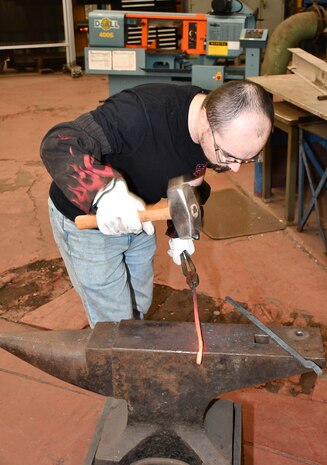 Norfolk Naval Shipyard Metal Forging Shop (Shop 11F) Metal Forger Jesse Dalton was first introduced to blacksmithing when he was 12-years-old. “I started playing World of Warcraft and the character I created was a blacksmith,” said Dalton. “At the time I didn’t know everything a blacksmith did, so I started Googling and found it very interesting. This led me to become a member of the Tidewater Blacksmiths Guild, learning how to blacksmith seven years before enrolling in NNSY’s apprenticeship program for metal forging.”