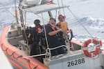 Crew members assigned to Coast Guard Cutter Reliance (WMEC 615) are lowered by the ship's davit for small boat operations in the Florida Straits, Jan. 31, 2025. Reliance conducted a 60-day patrol in the Florida Straits, Windward Passage and Gulf of America to safeguard U.S. maritime borders. (U.S. Coast Guard photo by Ensign Sarah Kaleta)