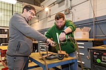 Norfolk Naval Shipyard Metals Inspector Apprentice Luke Truitt and Non-Destructive Testing (NDT) Metals Inspector Michael Hudson perform a NDT inspection on a shackle in the shop.