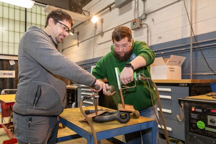Norfolk Naval Shipyard Metals Inspector Apprentice Luke Truitt and Non-Destructive Testing (NDT) Metals Inspector Michael Hudson perform a NDT inspection on a shackle in the shop.