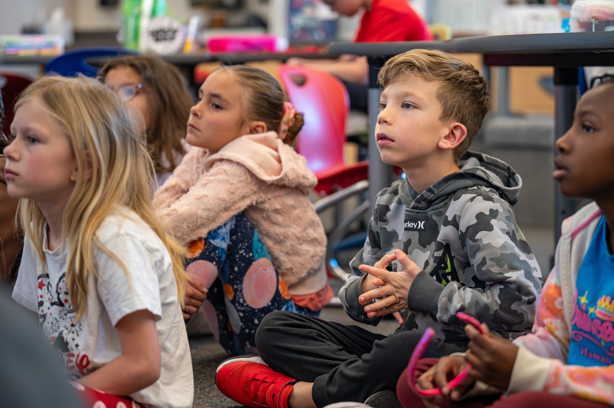 children sit on floor in classroom