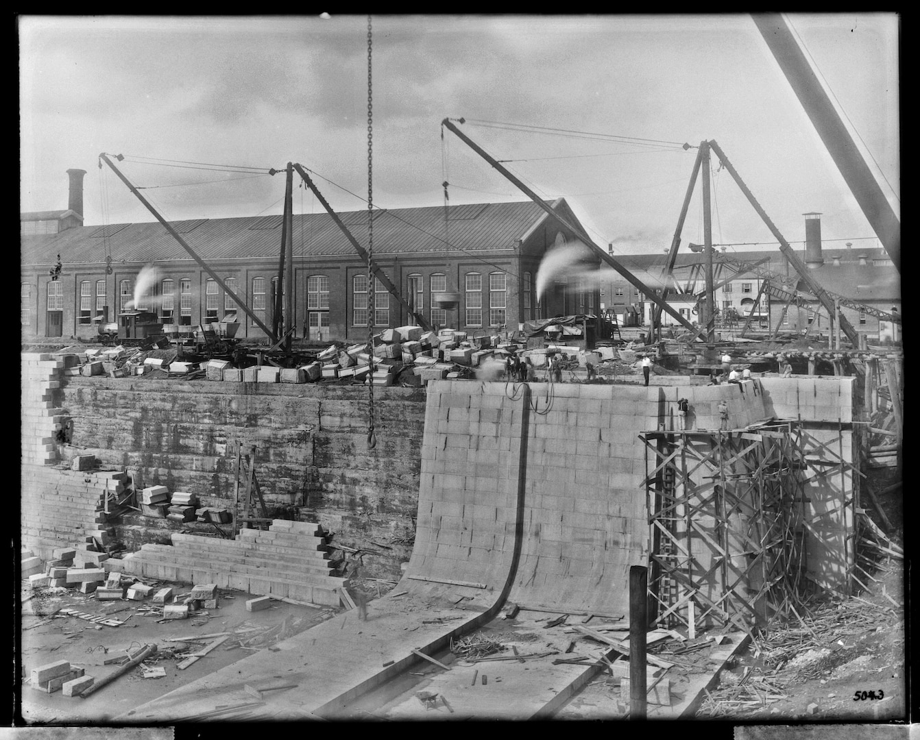 This photograph from October 4, 1906 shows the inner walls of Dry Dock 3 nearing completion as crew work on open scaffolding to finish the caisson side.