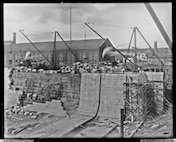 This photograph from October 4, 1906 shows the inner walls of Dry Dock 3 nearing completion as crew work on open scaffolding to finish the caisson side.