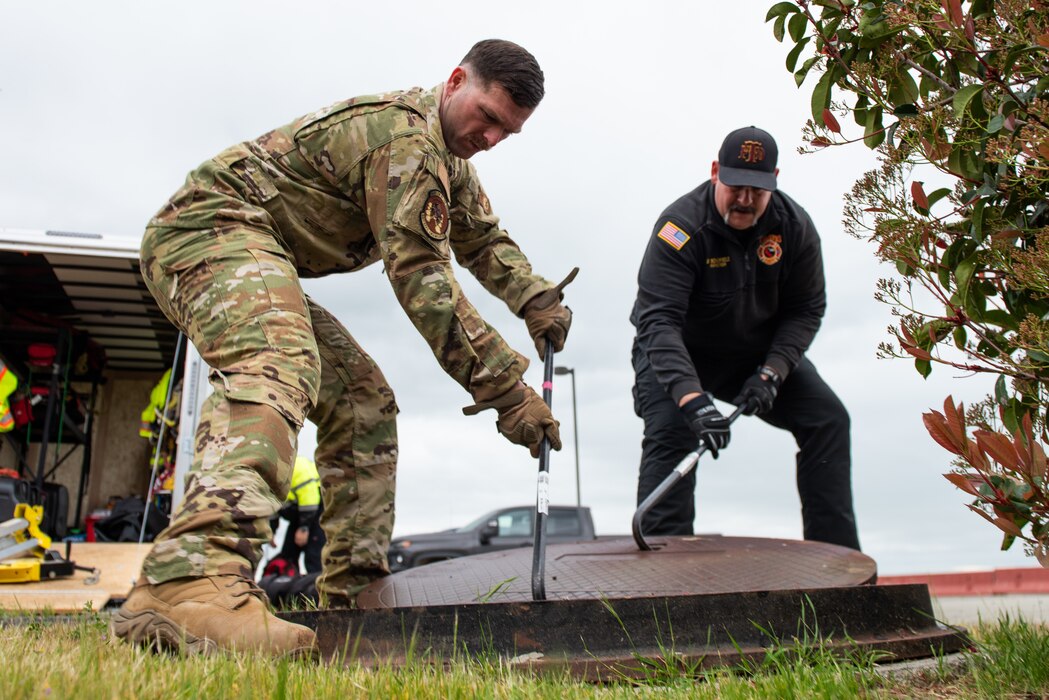 Airmen remove a manhole cover for confined space safety training