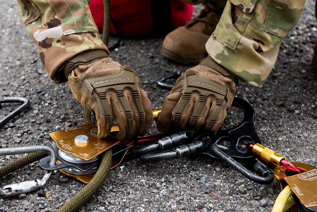 An Airman connects rescue riggings to an anchor plate for confined space safety training