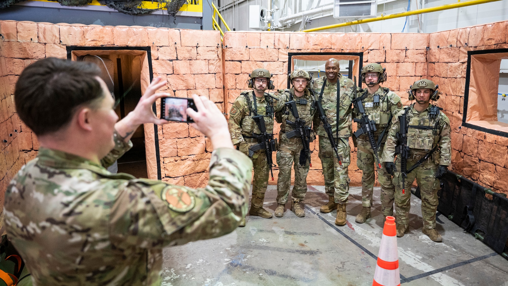Chief Master Sgt. Nicholas Taylor, 20th Air Force Command Chief Master Sergeant, poses for a group photo with Airmen from the 91st Missile Security Operations Squadron (91MSOS) at Minot Air Force Base, North Dakota, March 11, 2025. The 91MSOS uses airsoft guns to practice a variety of scenarios within the squadron’s training bay. (U.S. Air Force photo by Senior Airman Kendra A. Ransum)