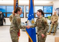 U.S. Air Force Maj. Gen. Stacy Jo Huser, 20th Air Force Commander, presents a coin to Senior Airman Abigail Christian, 91st Missile Security Forces Squadron, at the Dakota Inn Dining Facility on Minot Air Force Base, North Dakota, March 12, 2025. Huser coined a few 91st Missile Wing Airmen and had a group breakfast with around 20 other Airmen. (U.S. Air Force photo by Senior Airman Kendra A. Ransum)