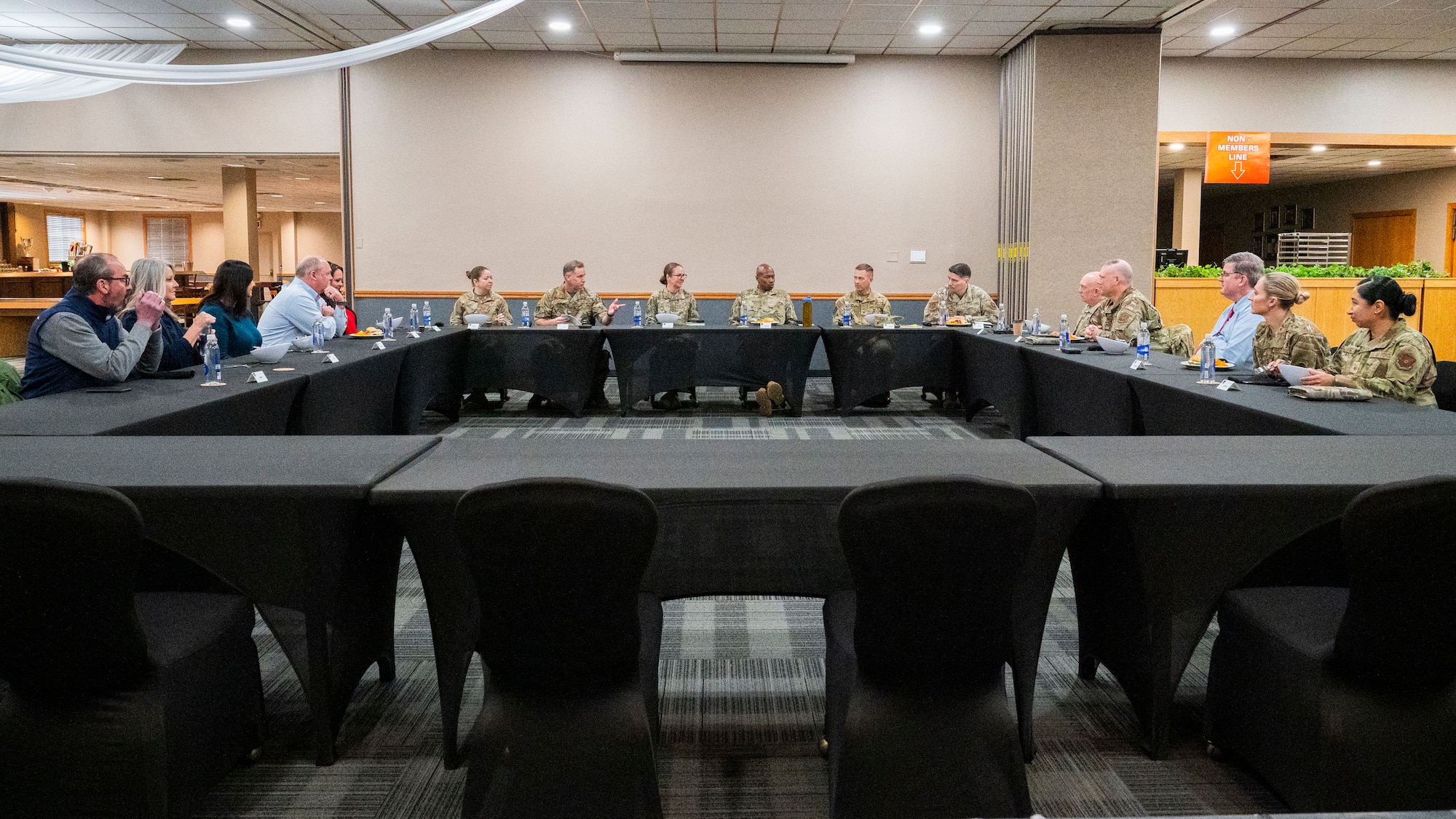 U.S. Air Force personnel from the 20th Air Force, 91st Missile Wing and local civic leaders talk during a group lunch at the Jimmy Doolittle Center on Minot Air Force Base, North Dakota, March 11, 2025. U.S. Air Force Maj. Gen. Stacy Jo Huser, the 20th Air Force Commander, and Chief Master Sgt. Nicholas Taylor, the 20th Air Force Command Chief Master Sergeant, visited many base facilities to observe the mission of Team Minot. (U.S. Air Force photo by Senior Airman Kendra A. Ransum)