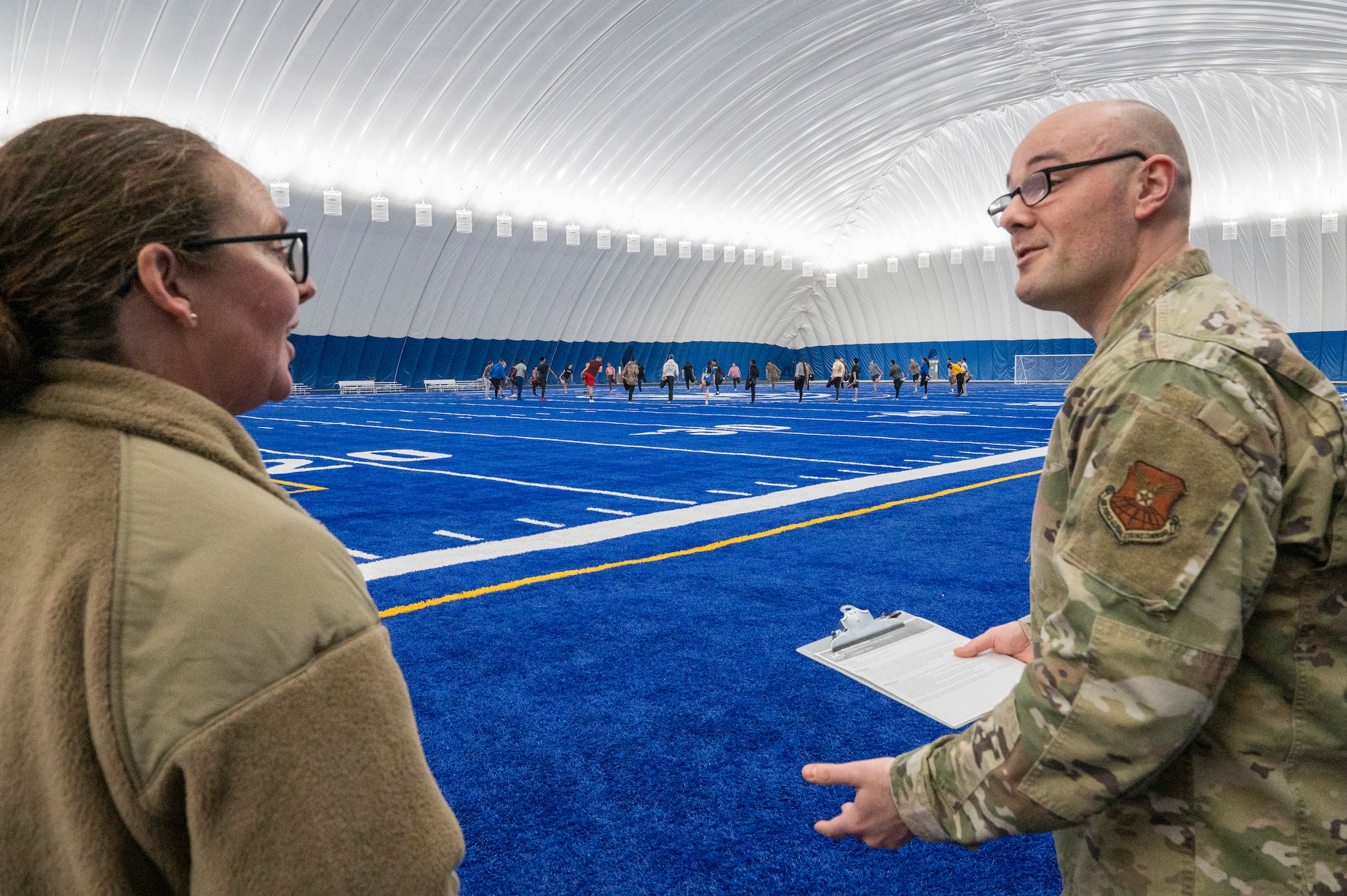 U.S. Air Force Maj. Gen. Stacy Jo Huser, 20th Air Force Commander, listens to Tech. Sgt. Gabriel Garrison, the fitness section chief from the 5th Force Support Squadron, explaining the Air Supported Dome they are in on Minot Air Force Base, North Dakota, March 11, 2025. The Dome is an extension of the base’s McAdoo Fitness Center and serves as a climatized area sporting a quarter-mile track and a turf field to host intramural sports, group fitness classes and unit physical training. (U.S. Air Force photo by Senior Airman Kendra A. Ransum)