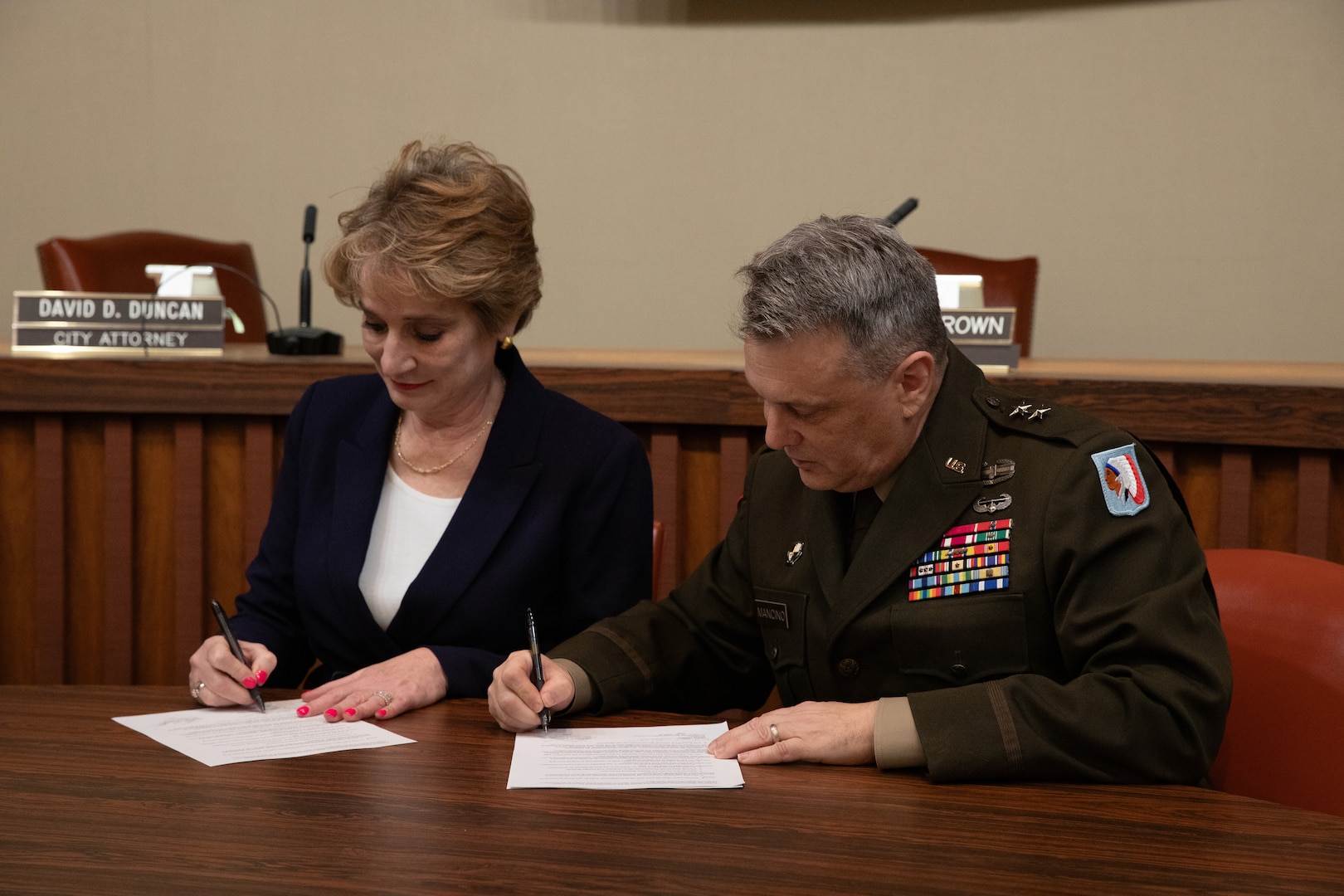 Dr. Diana Lovell, Southwestern Oklahoma State University president, and Maj. Gen. Thomas H. Mancino, adjutant general for Oklahoma, sign a memorandum of agreement outlining each party’s commitment to the continuation of the Guard Officer Leadership Development program, allowing commissioning opportunities for current-serving Oklahoma Army National Guard Soldiers and SWOSU students, at Weatherford city hall in Weatherford, Oklahoma, March 12, 2025. (Oklahoma National Guard photo by Sgt. Tyler Brahic)